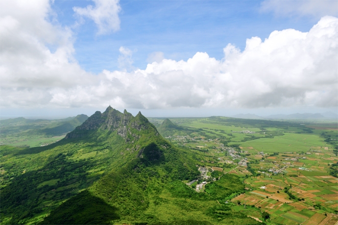 Panoramic view of a mountain range jutting out from the green earth