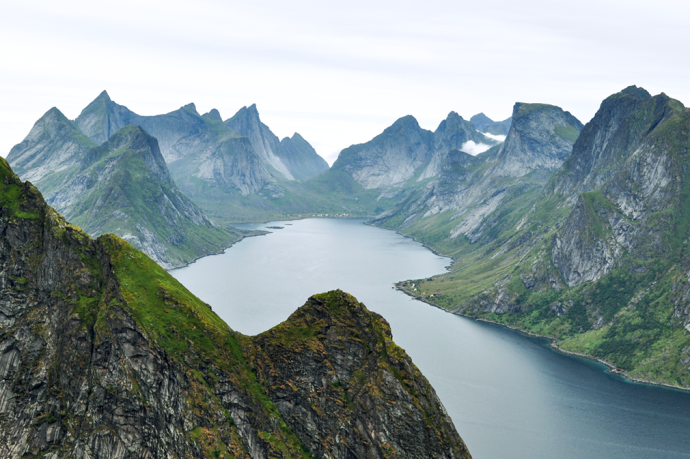 A dramatic landscape of jagged mountain peaks and a wide fjord