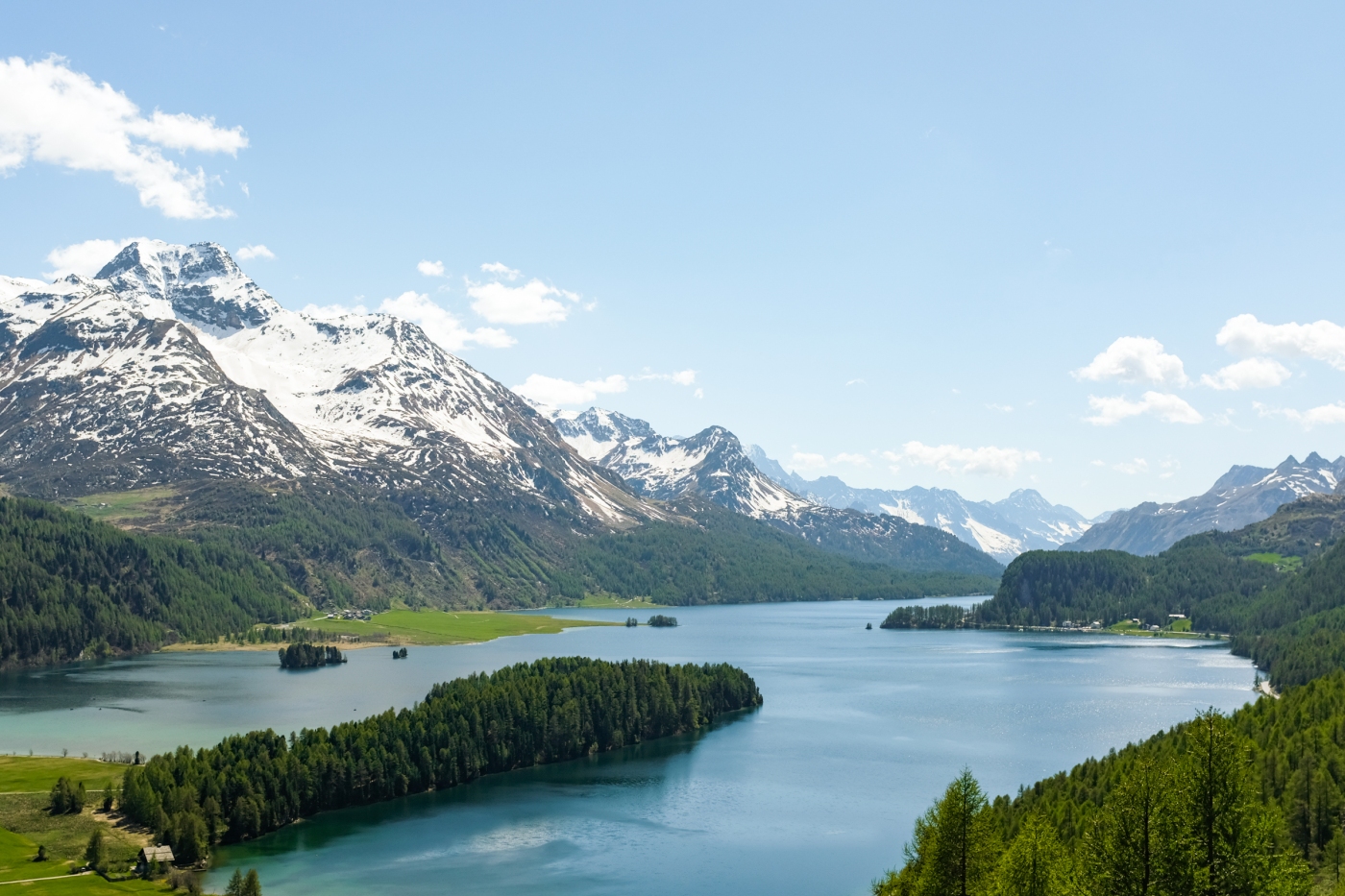 A forested peninsula juts into an alpine lake
